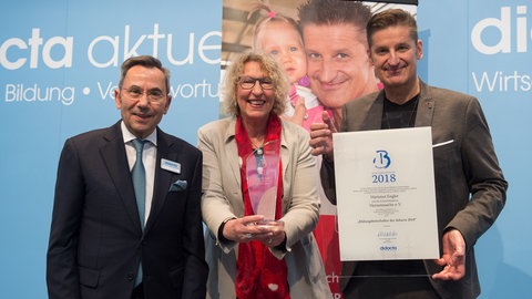 Hartmut Engler und Gitta Haucke von Herzenssache freuen sich über die Bildungsbotschafter Auszeichnung von Didacta Präsident Prof. Dr. mult. Fthenakis.